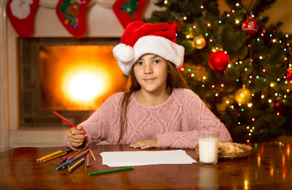 Menina bonito esperando Papai Noel com leite e biscoitos na sala de estar — Fotografia de Stock