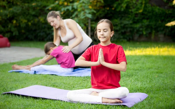 Linda chica haciendo yoga durante la lección al aire libre en el parque — Foto de Stock