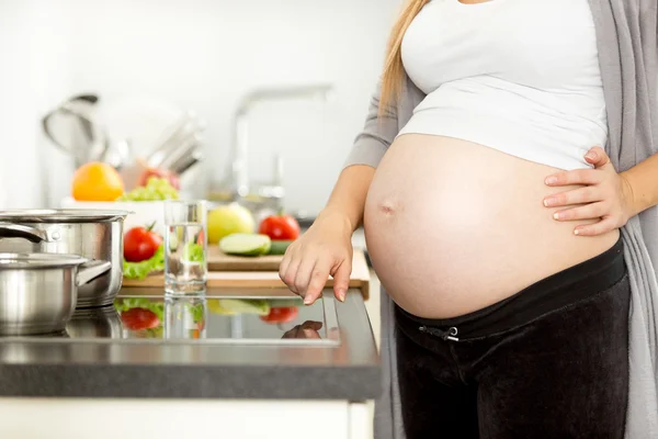 Primer plano de la mujer embarazada encendiendo la estufa eléctrica — Foto de Stock