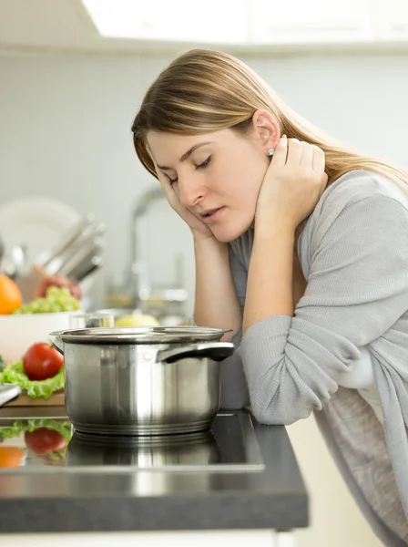 Üzgün kadın mutfakta masada yaslanmış — Stok fotoğraf