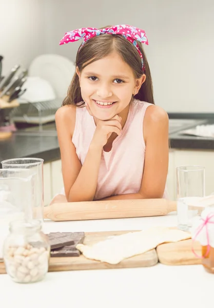 Retrato de linda chica sonriente posando en la cocina mientras hace dou —  Fotos de Stock