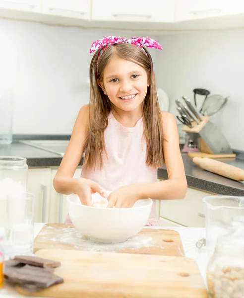 Χαμογελαστό κορίτσι κάνοντας ζύμη για πίτα σε λευκή γυάλα — Φωτογραφία Αρχείου