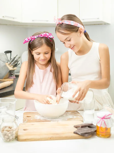 Sorridente ragazza facendo pasta in ciotola bianca sulla cucina — Foto Stock