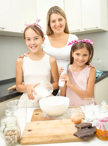Улыбающаяся семья делает тесто для пирога на кухне — стоковое фото