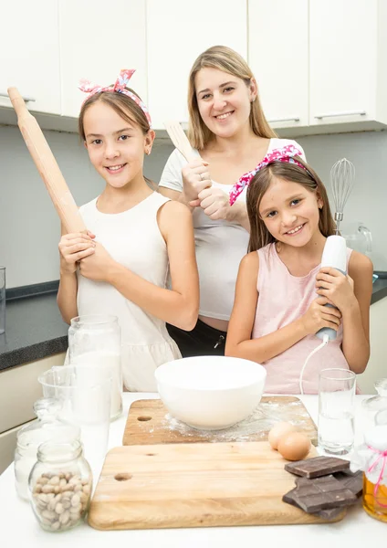 Madre e due figlie in posa con utensili da cucina — Foto Stock