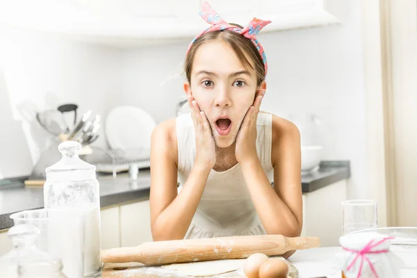 Ενθουσιασμένος κορίτσι παλαμάκια για τα μάγουλα της με αλεύρι κατά το μαγείρεμα — Φωτογραφία Αρχείου