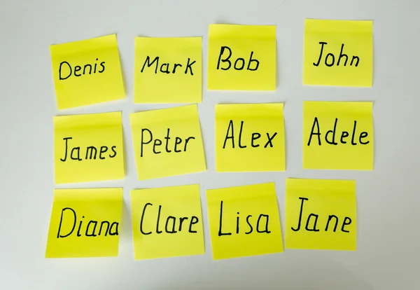 Closeup de adesivos de papel amarelo com nomes masculinos e femininos — Fotografia de Stock