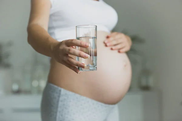 Closeup of pregnant woman holding glass of water — Stock Photo, Image