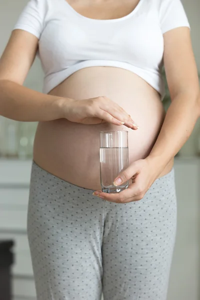 Closeup of pregnant woman posing with glass of water — Stock Photo, Image