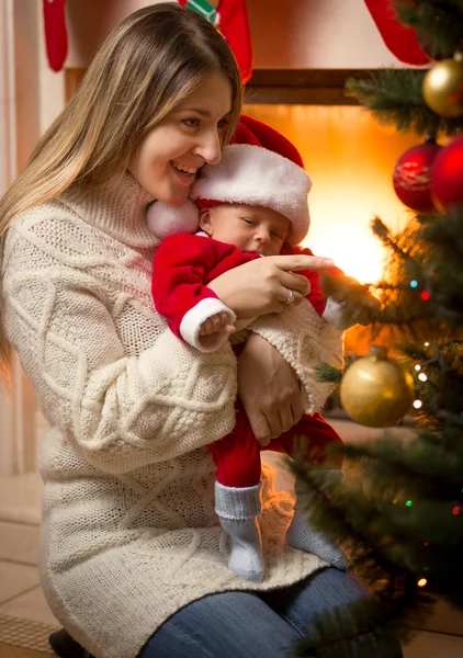 Moeder en baby zoon in Santa kostuum Christmas tree decoreren — Stockfoto