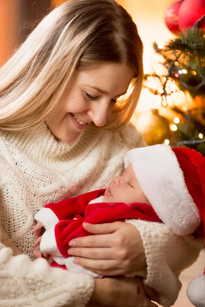 Mutlu anne sarılma bebek çocuk Noel Baba kostüm, şömine — Stok fotoğraf