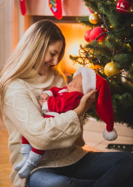 クリスマス暖炉のそばで座っている母と赤ちゃんの男の子の肖像画 — ストック写真