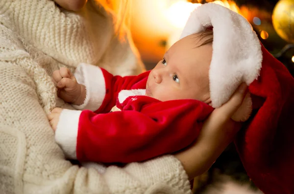 Fechar-se da mãe segurando bebê menino em Santa traje e chapéu — Fotografia de Stock
