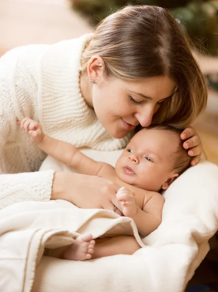 Portrait of caring mother kissing baby boy son lying on white bl — Stock Photo, Image