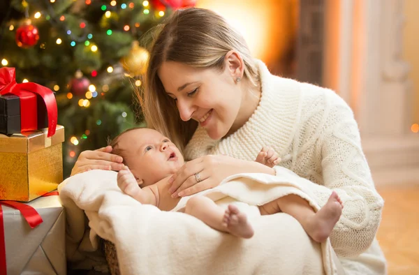 Mãe feliz com bebê recém-nascido sob a árvore de Natal — Fotografia de Stock