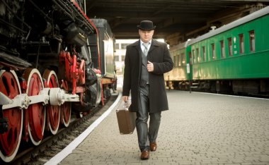 Tren platformu üzerinde yürüme çanta retro elbiseli adam