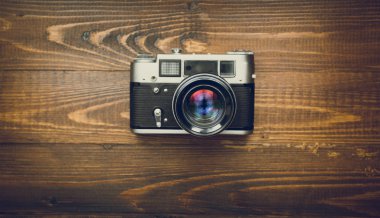 Ahşap arka plan üzerinde manuel lens ile eski fotoğraf makinesi tonlu görüntü