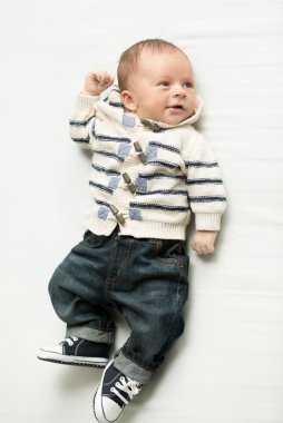 yatakta yatarken bebek boy gülümseyerek