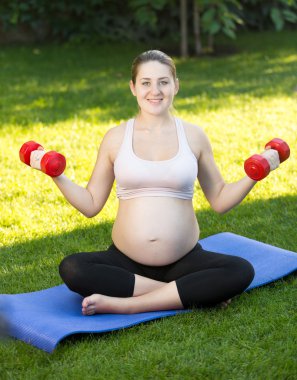 Park dumbbells ile pratik hamile kadın portresi