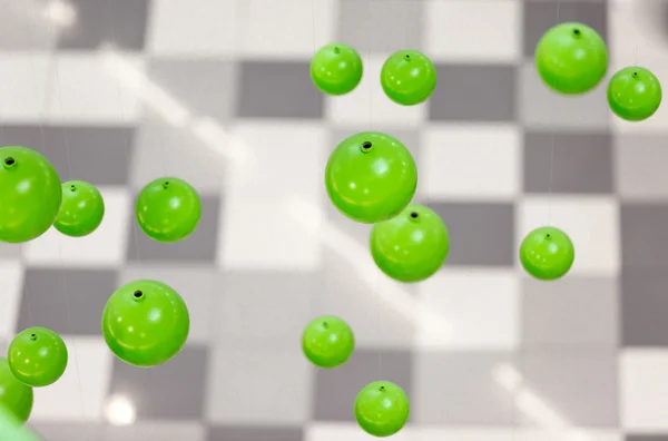 Imagem abstrata de esferas verdes 3d caindo sobre fundo cinza — Fotografia de Stock