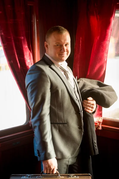 Smiling man in retro suit traveling in old train — Stock Photo, Image