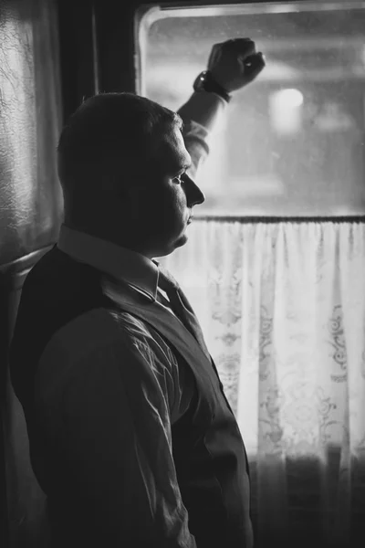 Портрет красивого мужчины в костюме, выглядывающего в окно в ретро — стоковое фото