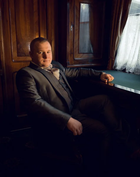 Retro styled portrait of businessman sitting in armchair at offi — Stock Photo, Image