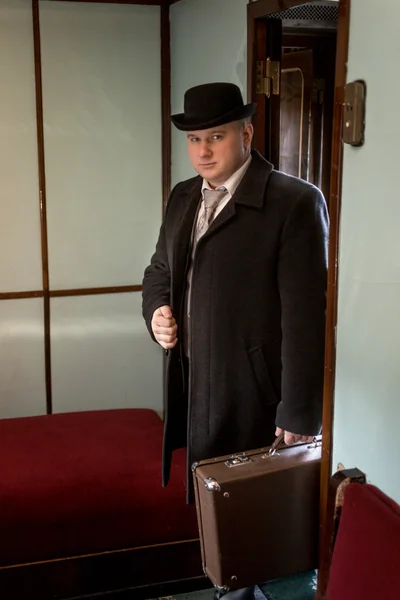 Photo tonique de l'homme en chapeau melon marchant dans le coupé de train — Photo