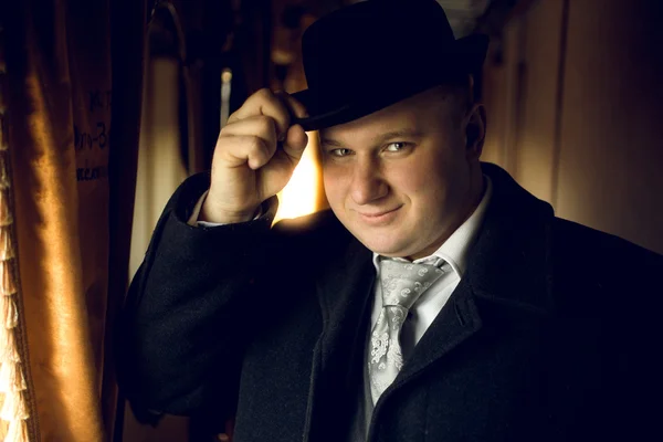 portrait of man in vintage clothes posing in train