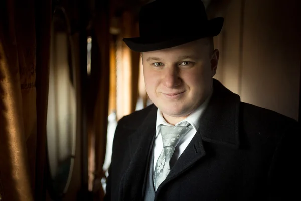 Portrait of smiling man in bowler hat posing in retro train — Stock Photo, Image