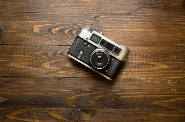 Manual camera lying on old wooden background — Stock Photo, Image
