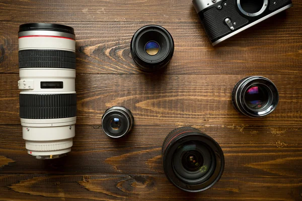 Oldtimer-Kamera und verschiedene Objektive auf Holzgrund — Stockfoto
