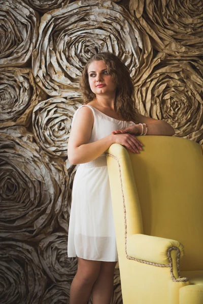 Elegant beautiful woman leaning on big armchair — Stock Photo, Image