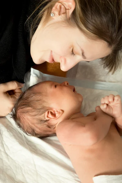 Ritratto di giovane madre sorridente sdraiata con il suo bambino di 1 mese — Foto Stock