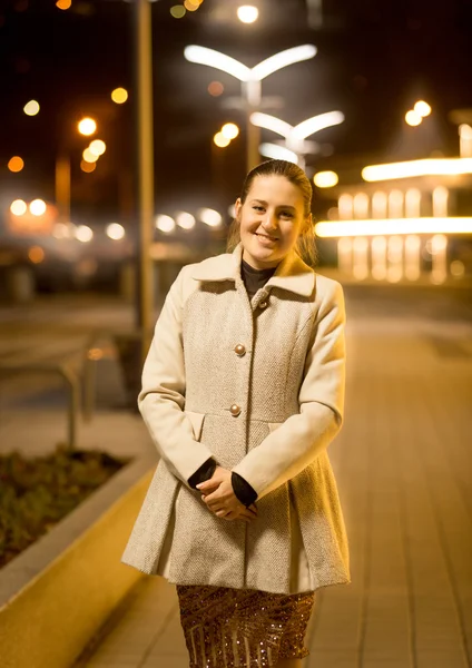 Glücklich elegante Frau posiert auf der Straße in der Nacht — Stockfoto