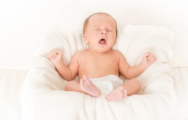 Retrato de lindo bebé acostado en la cama y bostezando — Foto de Stock