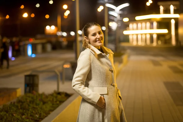 Портрет улыбающейся женщины, идущей по улице ночью — стоковое фото