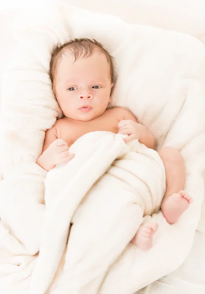 Söt baby liggande på sängen under täcket — Stockfoto