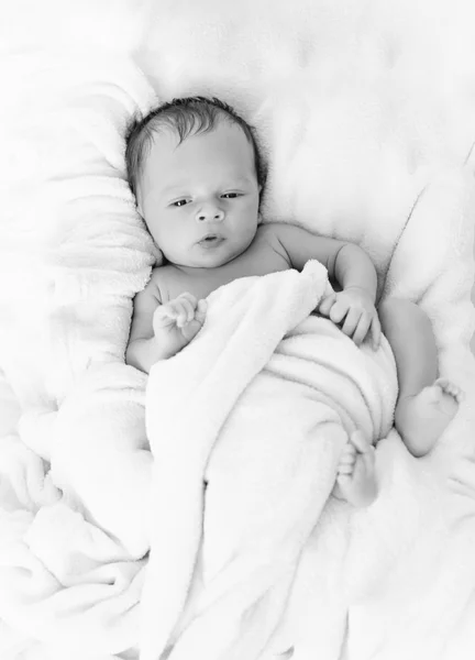 Schwarz-Weiß-Foto eines Jungen in Decke auf dem Bett — Stockfoto