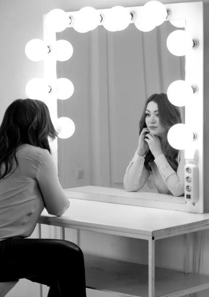 Monochrome portrait of brunette woman looking at reflection in m — Stock Photo, Image