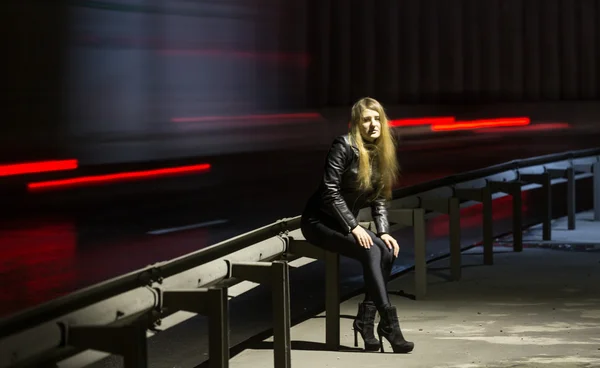 Ensamhet koncept. Kvinna poserar på motorvägen på natten — Stockfoto