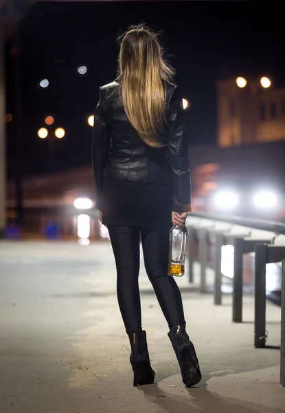 Bakifrån av kvinna poserar på motorvägen på natten — Stockfoto