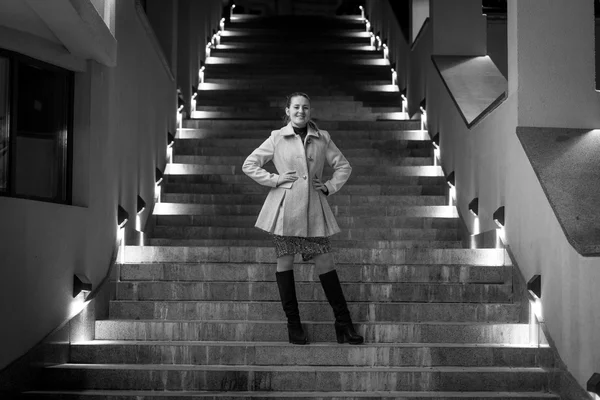 Preto e branco tiro de mulher elegante posando em escadas à noite — Fotografia de Stock