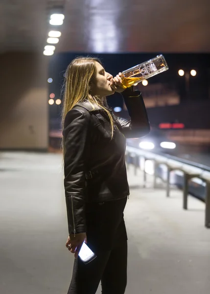 Portret van vrouw whiskey drinken uit flesje en nacht — Stockfoto