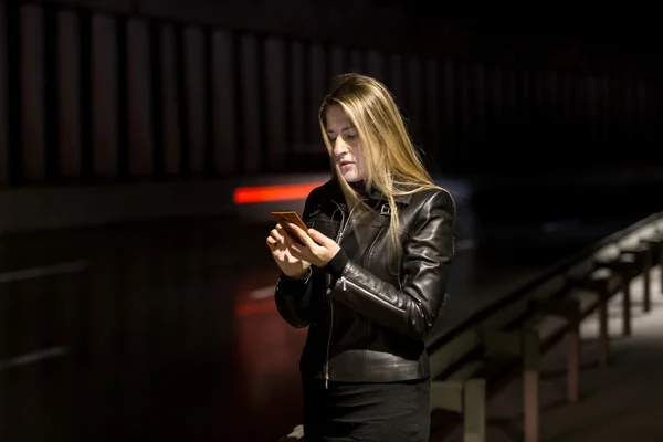 Night portrait of girl using mobile phone on street — Stock Photo, Image