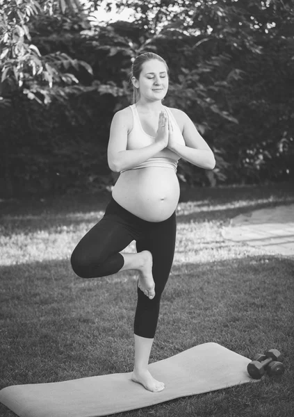 Czarno-białe zdjęcia ciąży kobieta stojąc na jednej nodze i p — Zdjęcie stockowe