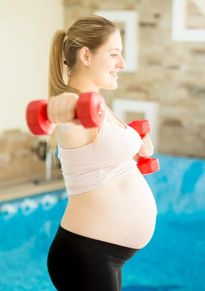 Mujer embarazada haciendo ejercicio con pesas — Foto de Stock