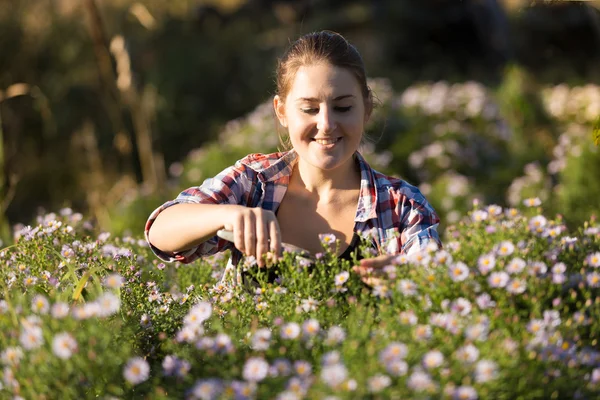 Retrato de mujer joven cortando flores en el jardín — Foto de Stock