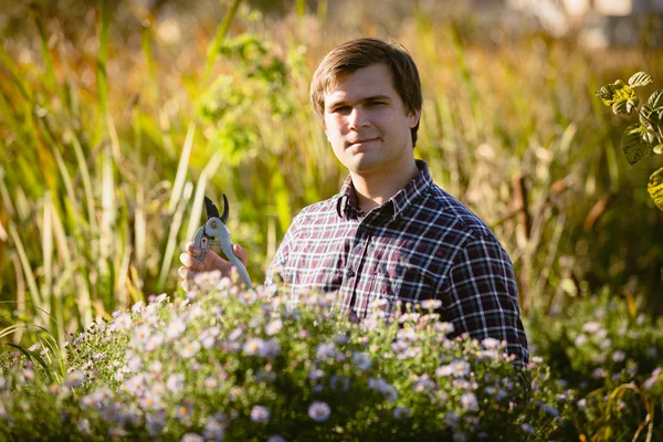 Arbetar unga trädgårdsmästare poserar på blomsterrabatt — Stockfoto