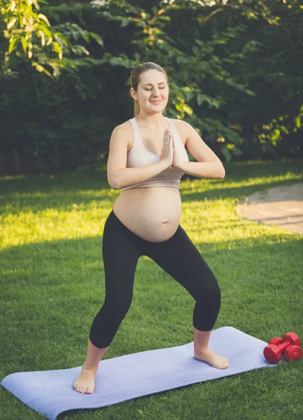 Kobieta w ciąży robi ćwiczenia jogi w parku — Zdjęcie stockowe